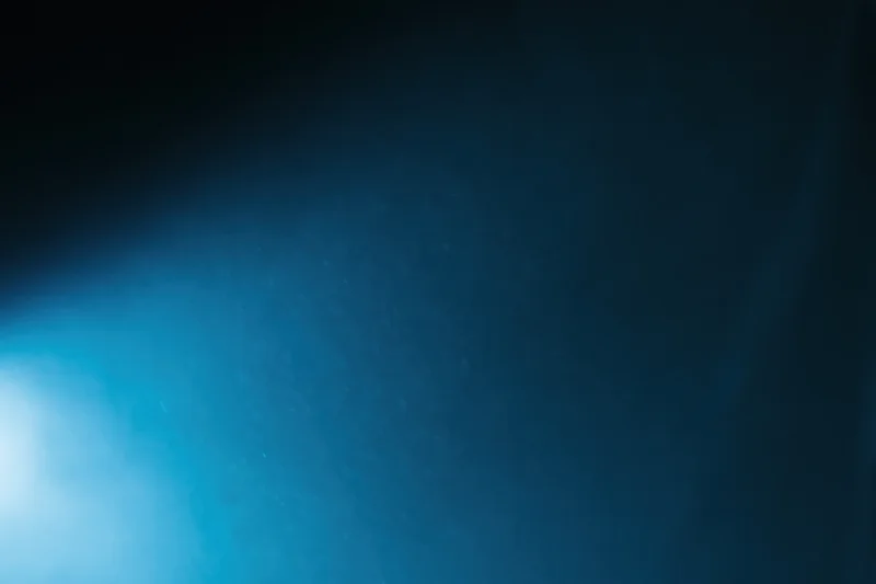 Dark navy blue gradient background with soft light glow and subtle particles