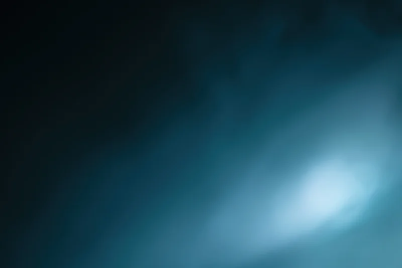 Abstract defocused background with soft glowing light source in blue and dark tones