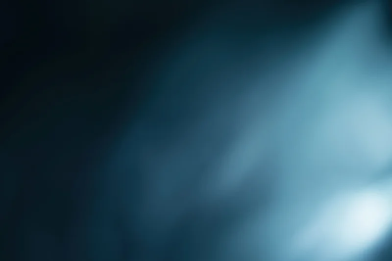 Abstract defocused background with soft glowing light source in blue and dark tones