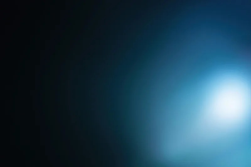 Abstract defocused background with soft glowing light source in blue and dark tones