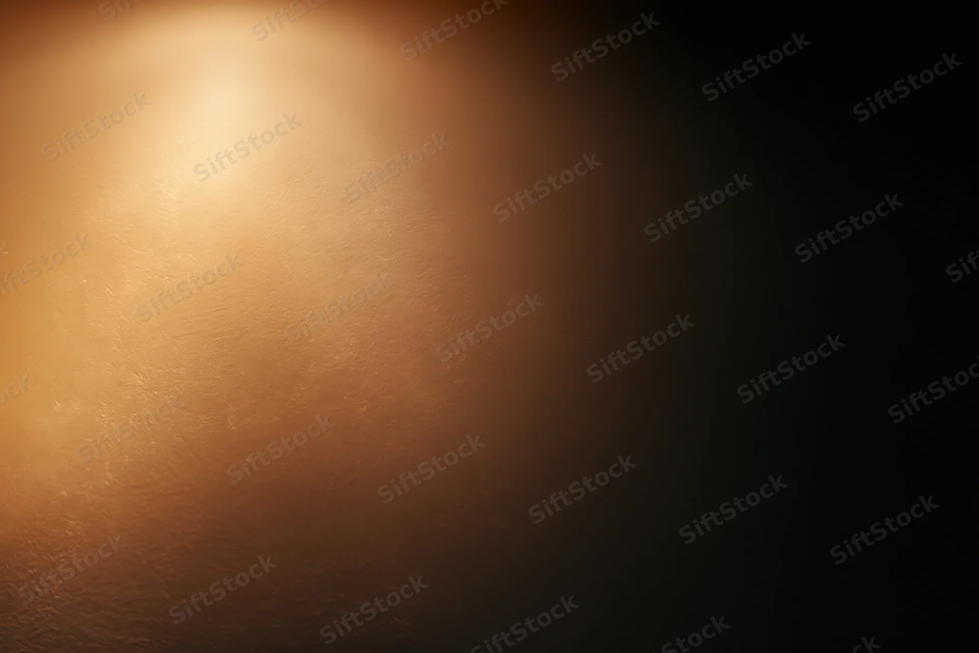 Warm spotlight glowing on a textured surface with dark edges