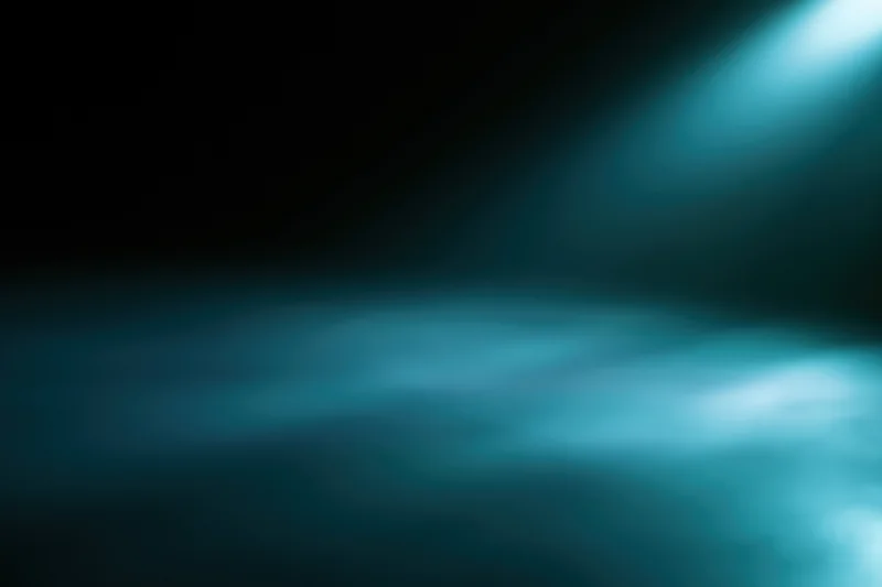 Soft-focused abstract background with teal light beam and dark gradient