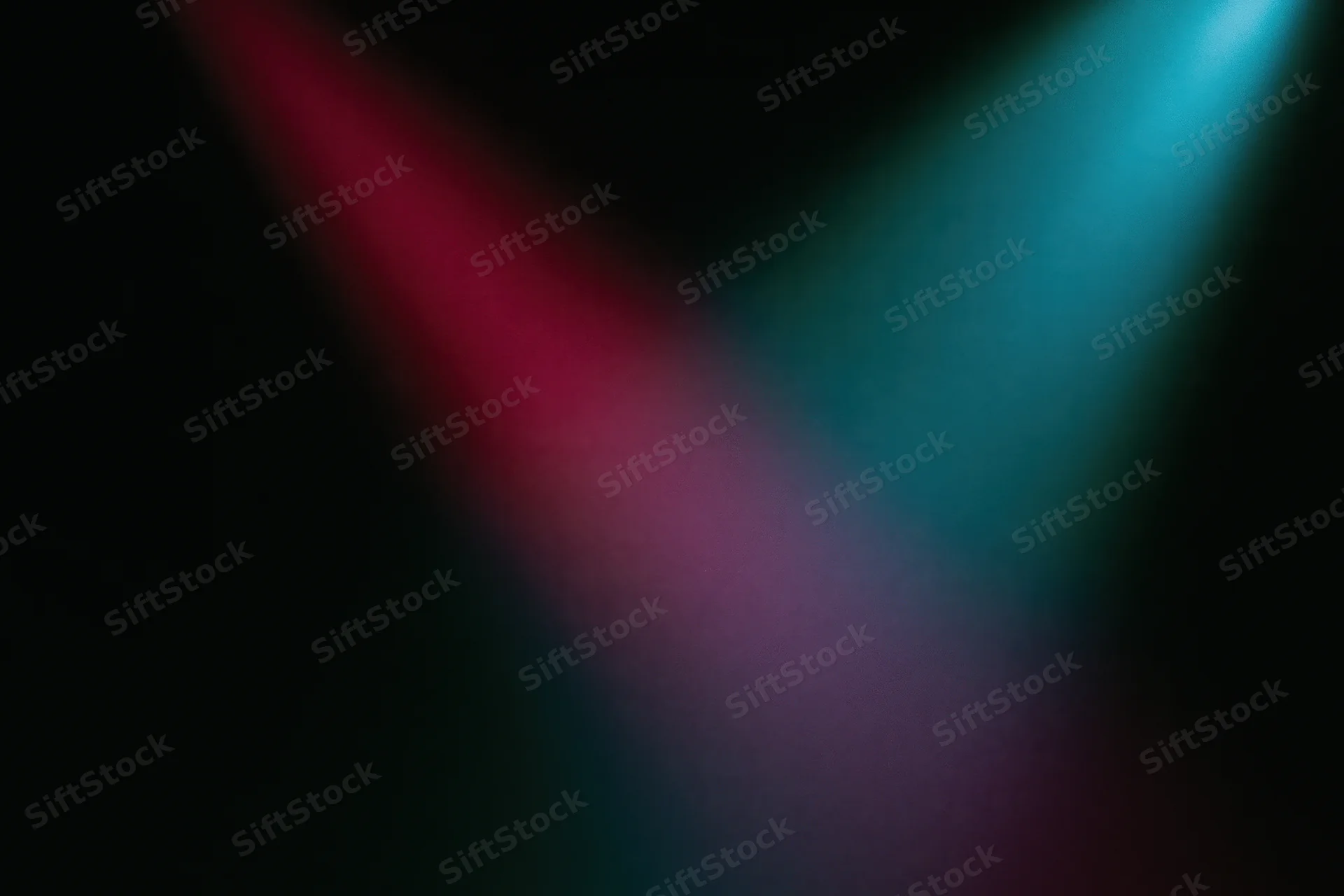 Two overlapping beams of red and blue stage lighting on a dark wall