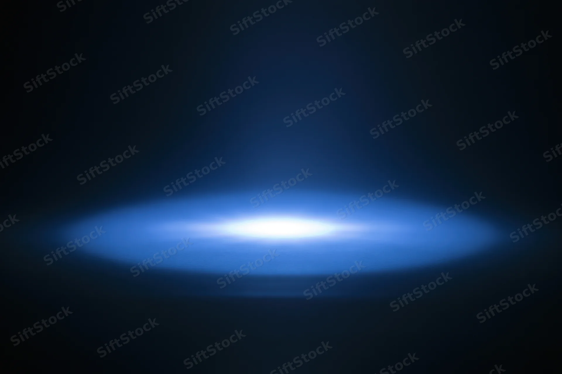 Soft blue radial light glow centered on dark studio background