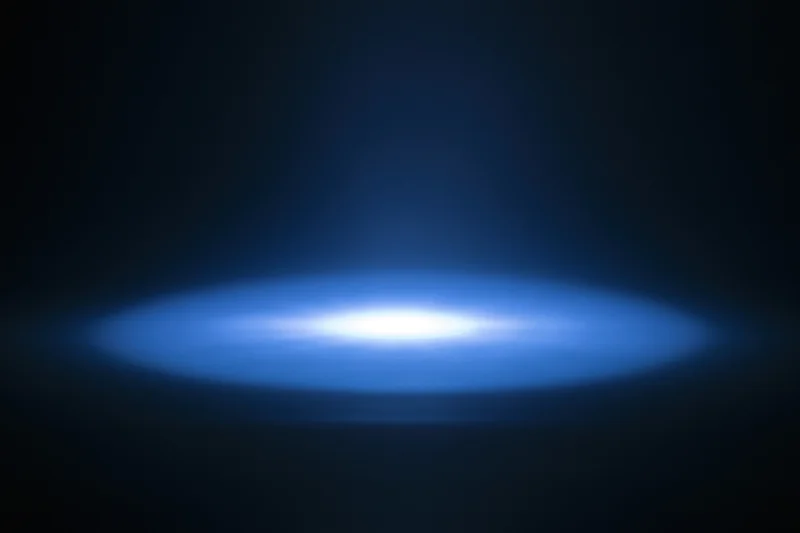 Soft blue radial light glow centered on dark studio background