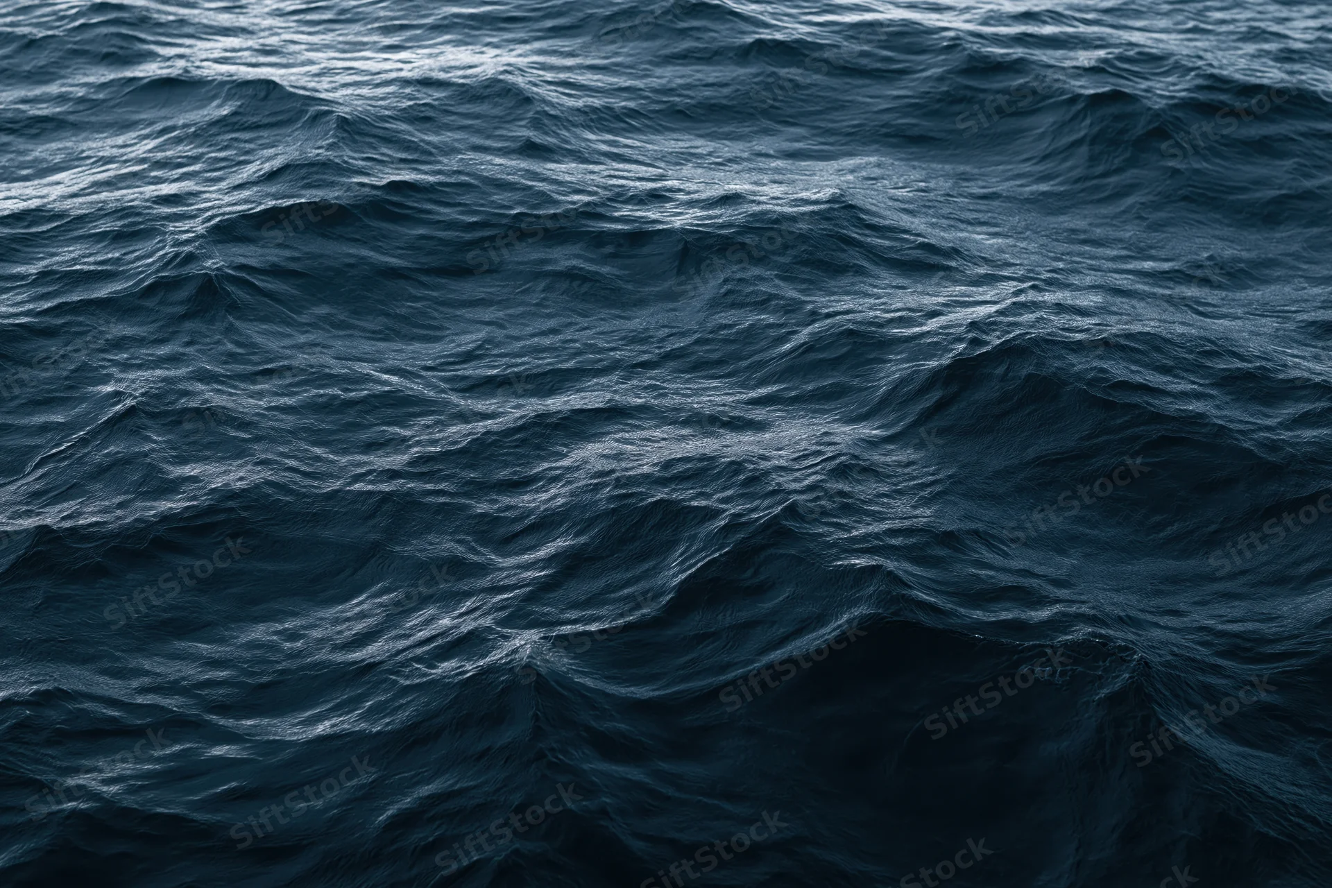 Dark choppy ocean surface with small waves and ripples, aerial close-up view