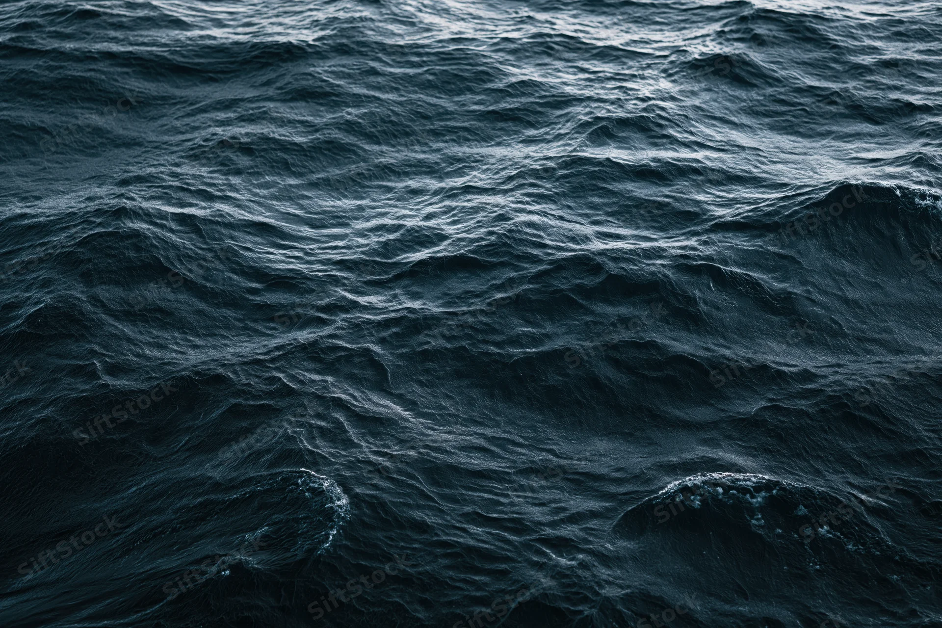 Dark choppy ocean surface with small waves and ripples viewed from above