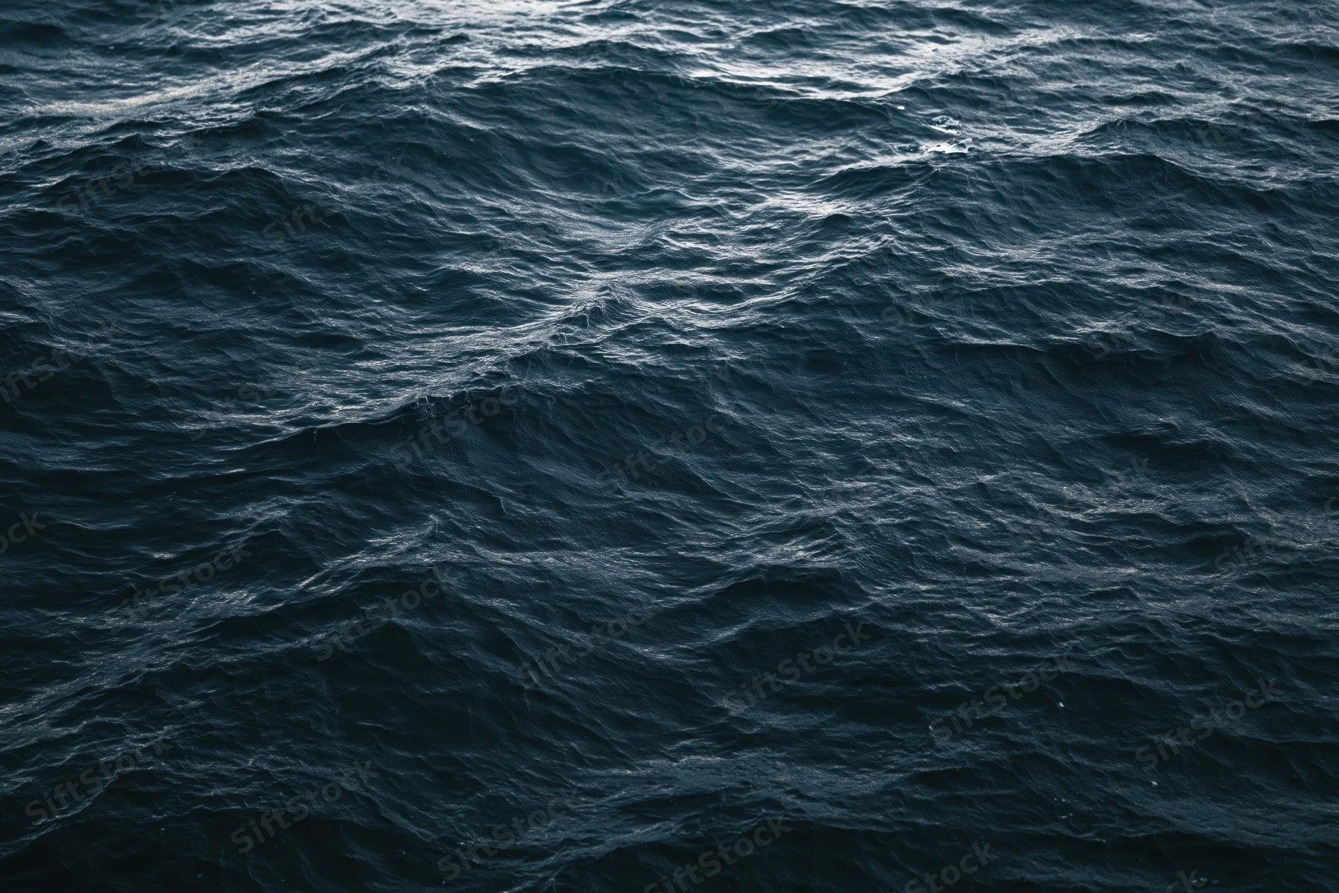 Dark choppy ocean surface with small waves and ripples under overcast light