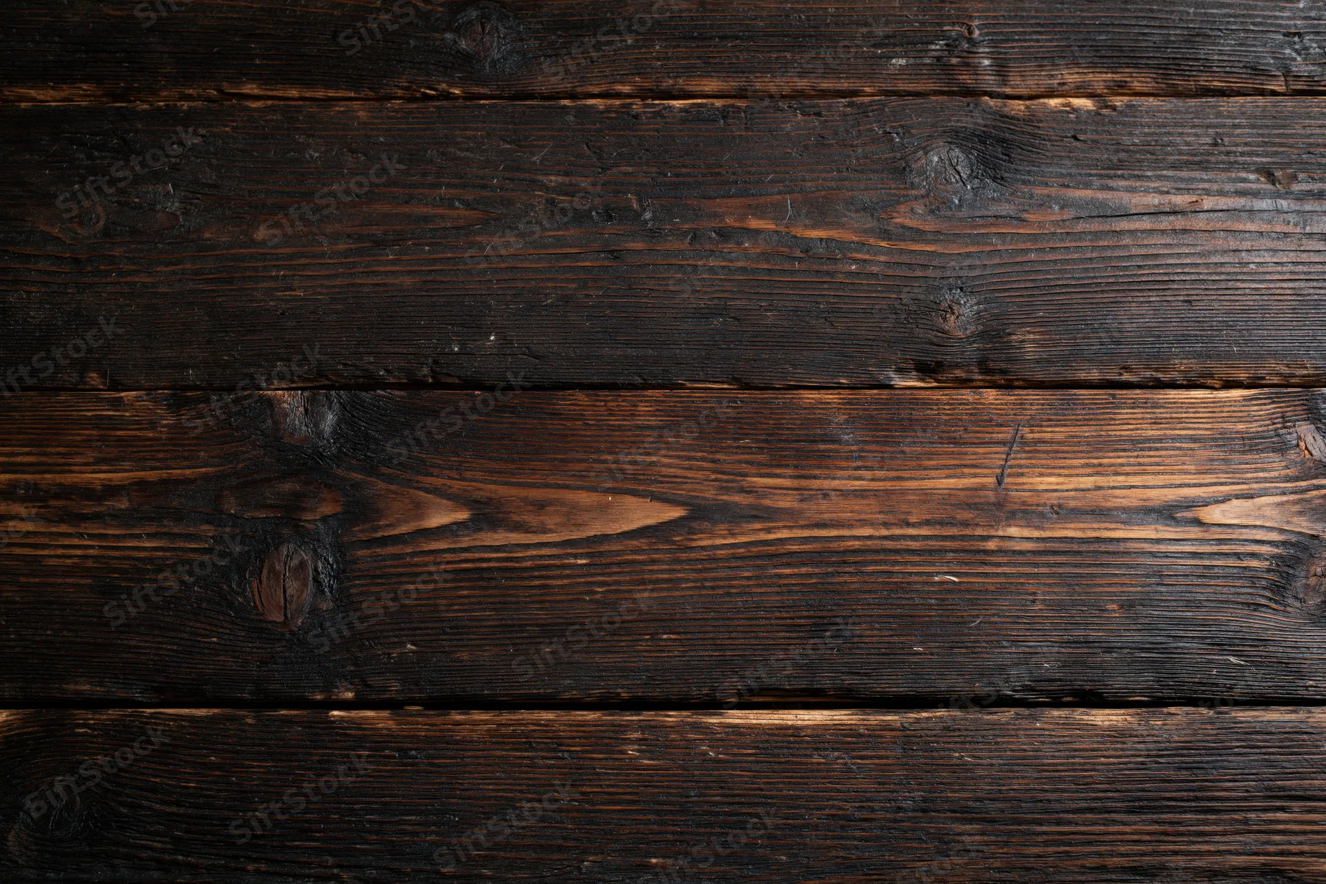 Dark aged wooden planks arranged horizontally as a textured surface