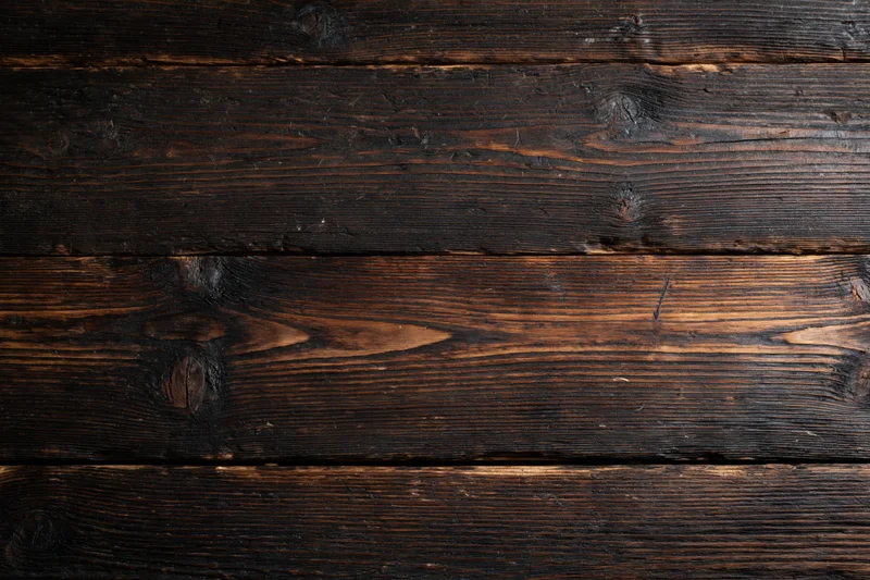 Dark aged wooden planks arranged horizontally as a textured surface
