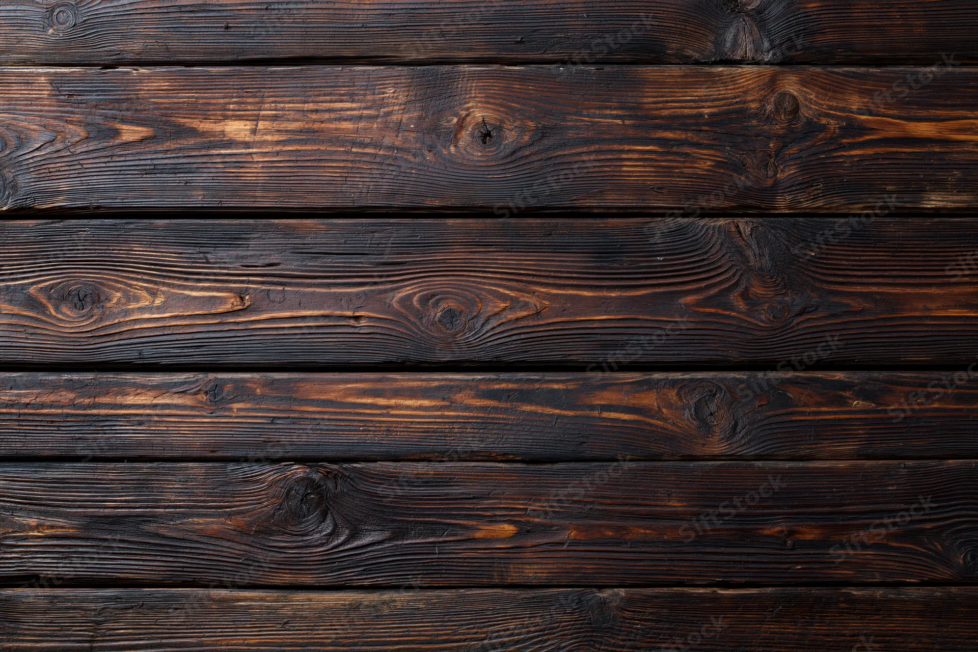 Dark aged wooden planks arranged horizontally as a textured surface