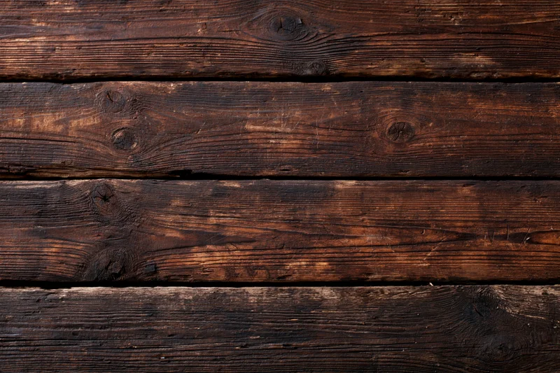 Dark aged wooden planks arranged horizontally as a textured surface