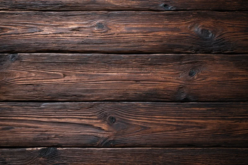 Dark aged wooden planks arranged horizontally as a textured flat lay surface