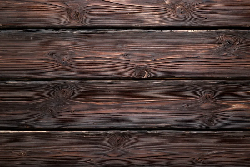 Horizontal dark aged wooden planks forming a flat surface with visible grain and knots