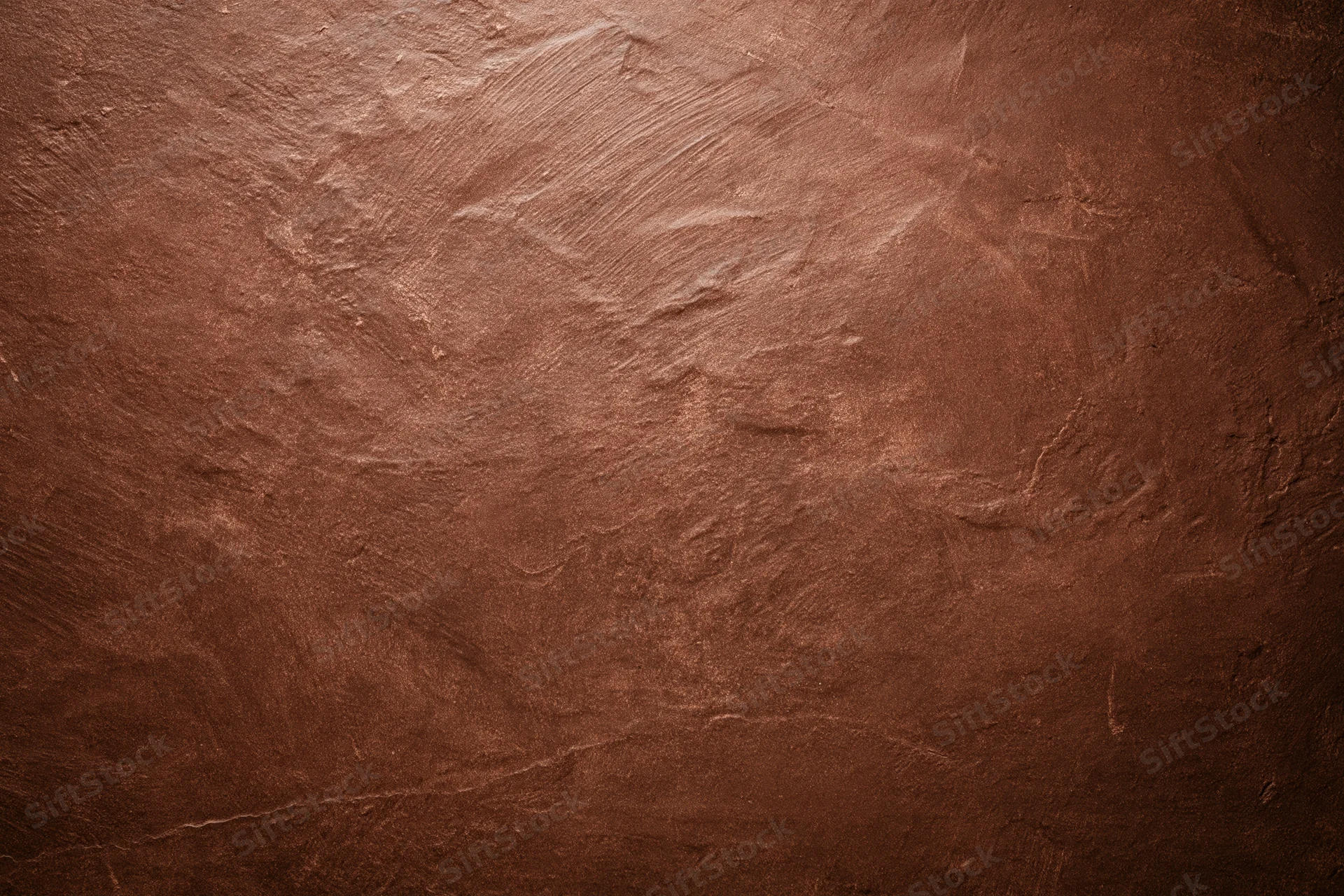 Aged plaster wall surface filling the frame with rough texture and warm brown tones