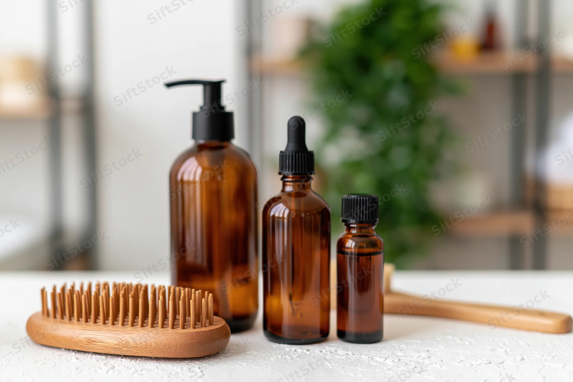 Amber glass hair care bottles with wooden brush on bathroom countertop
