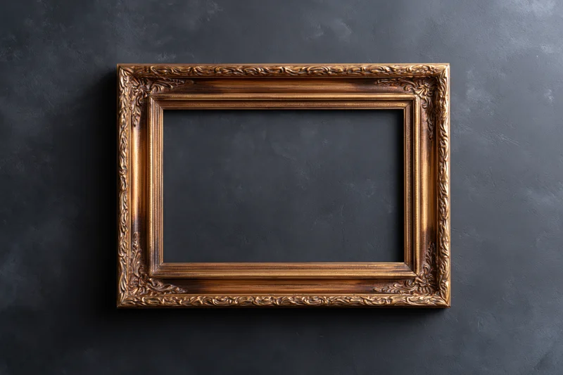 Ornate wooden picture frame with carved details hanging on dark textured wall