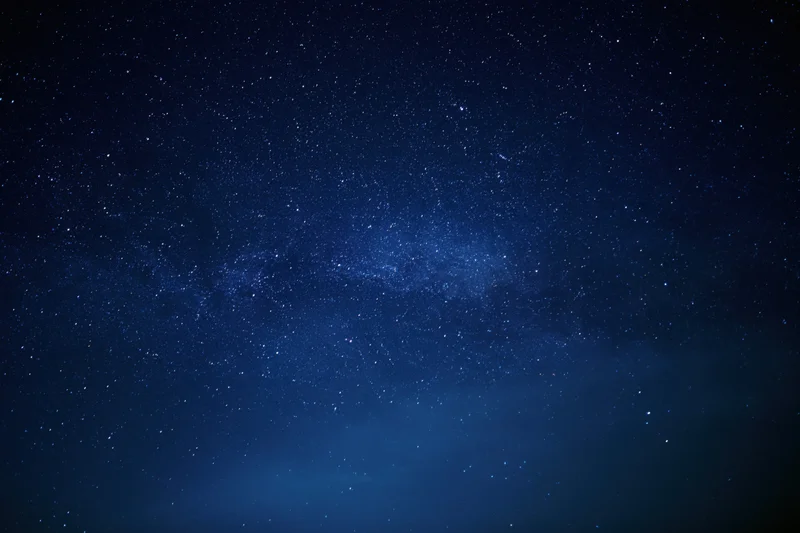Night sky filled with stars and the milky way visible across the dark blue expanse