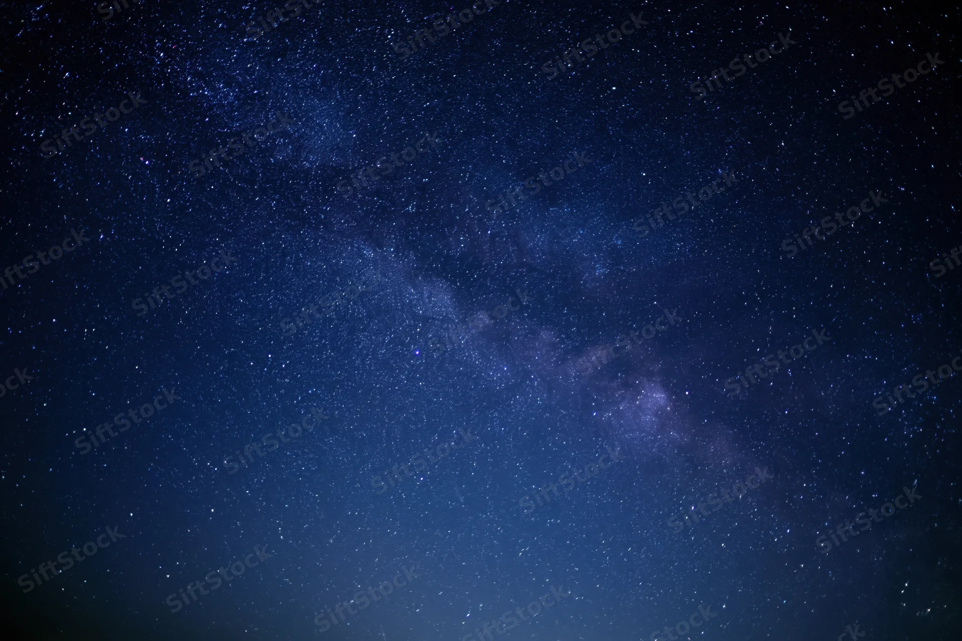 Night sky filled with stars and the milky way visible across the dark blue expanse