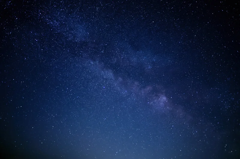 Night sky filled with stars and the milky way visible across the dark blue expanse