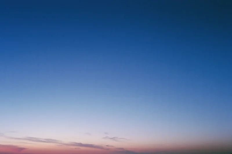 Twilight sky with soft gradient from deep blue to pink and purple near the horizon