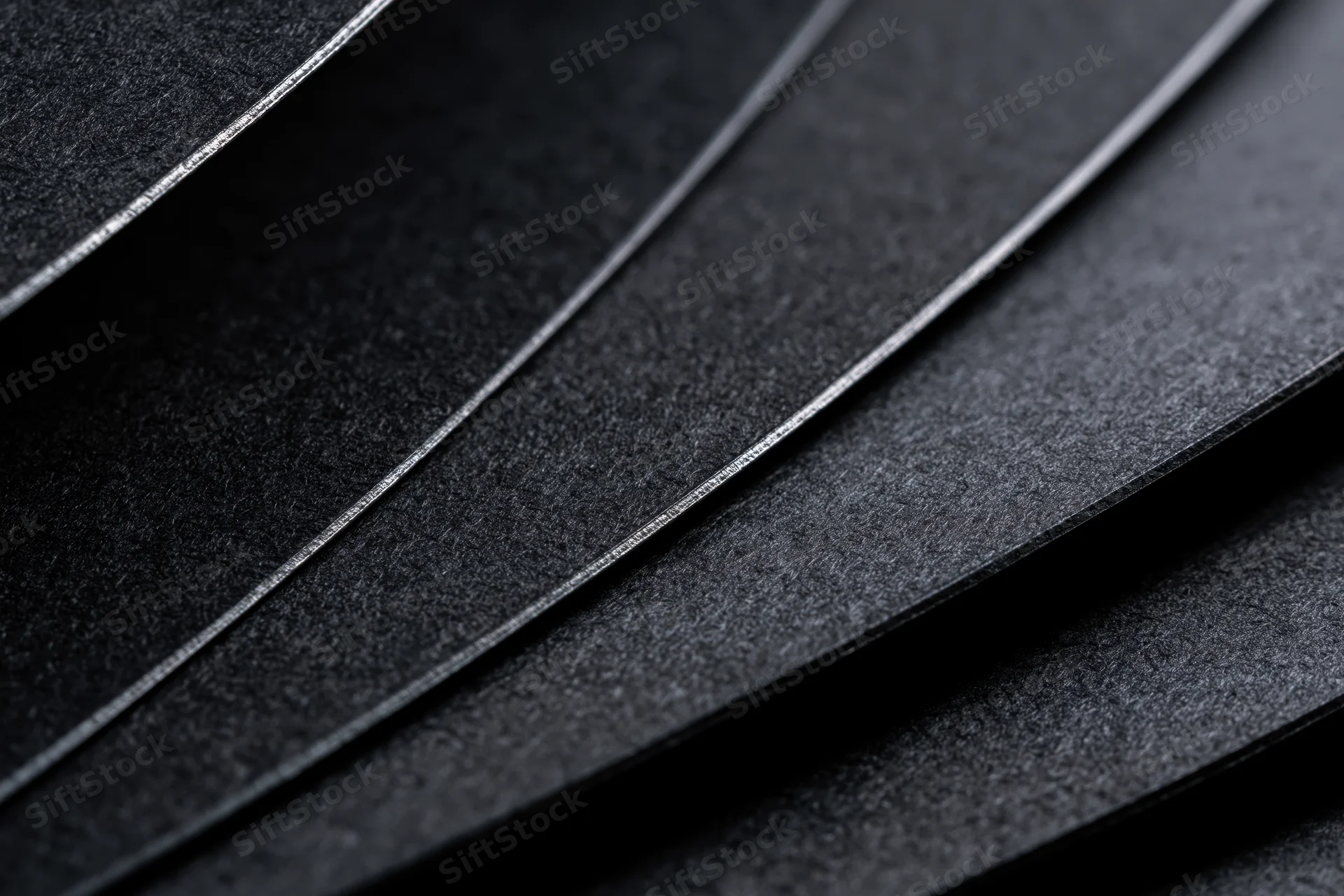 Curved black cardstock sheets layered in close-up abstract view