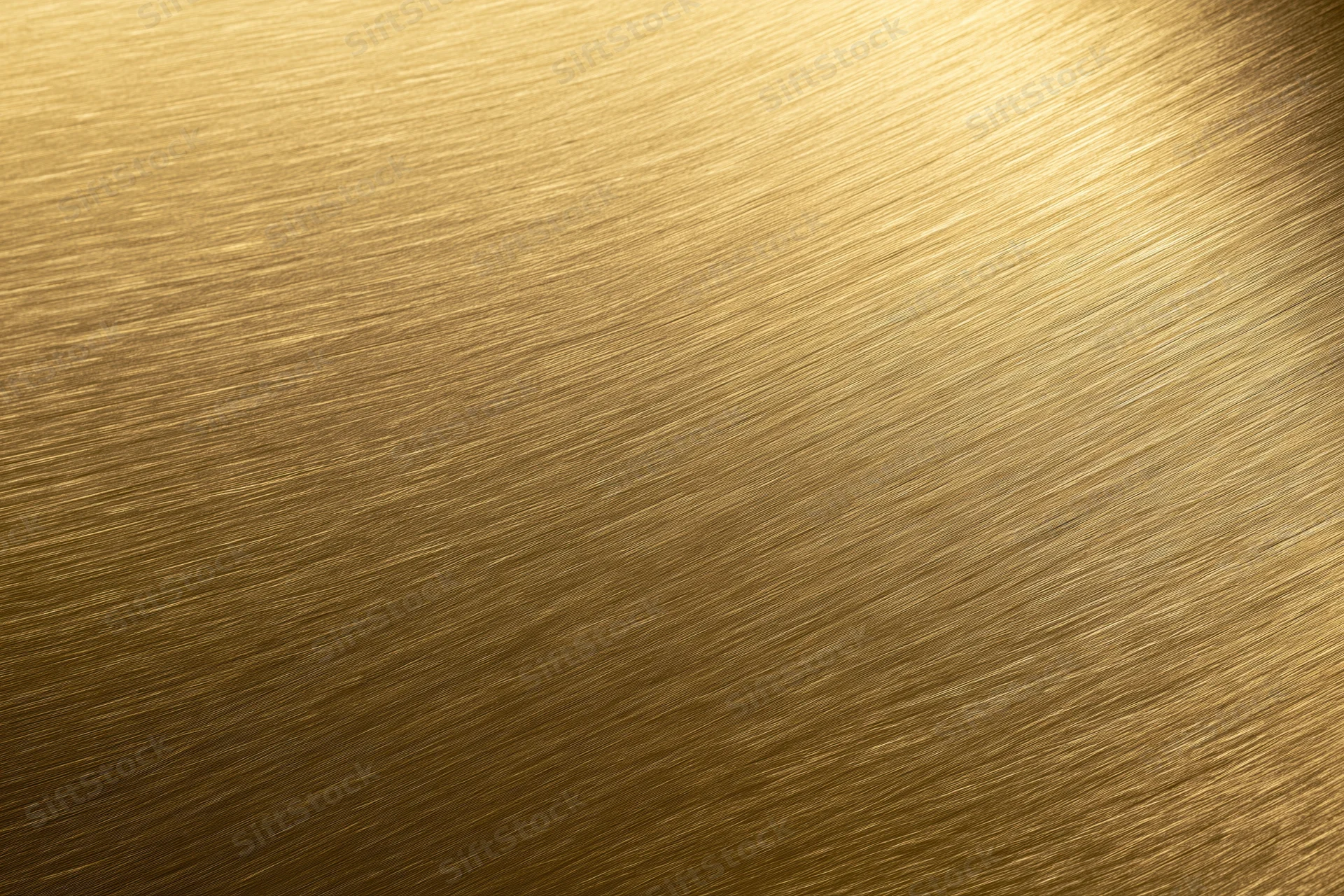 Close-up of brushed gold metal surface with diagonal texture and light gradient