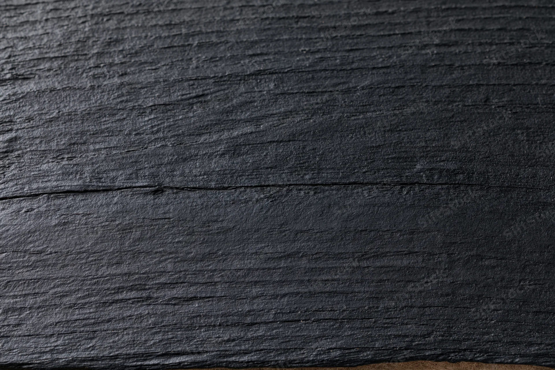 Close-up of dark black wooden surface showing natural grain and texture