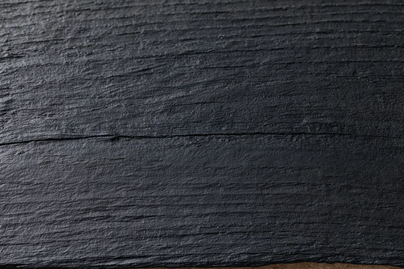 Close-up of dark black wooden surface showing natural grain and texture