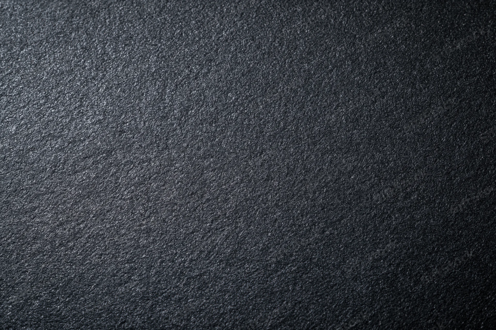 Close-up of dark charcoal matte paper surface with textured grain pattern