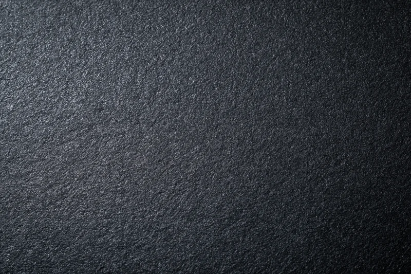 Close-up of dark charcoal matte paper surface with textured grain pattern