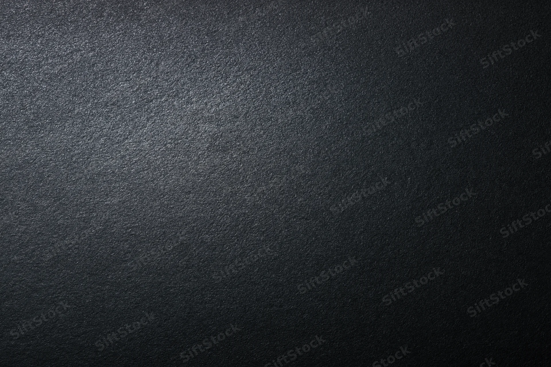 Close-up of dark matte textured surface with subtle gradient lighting