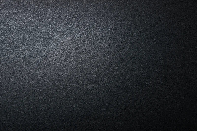 Close-up of dark matte textured surface with subtle gradient lighting