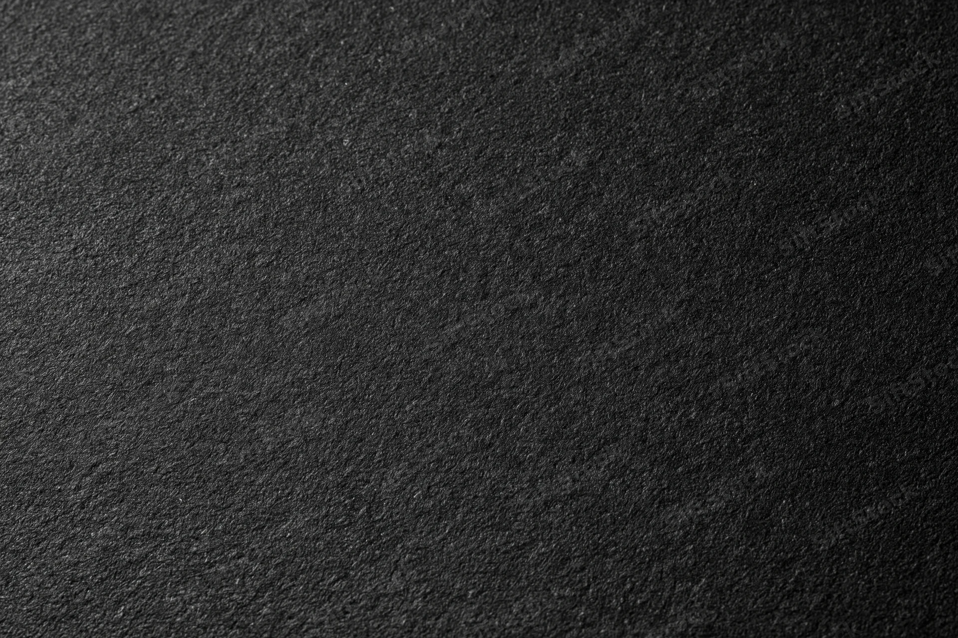 Close-up of dark charcoal matte paper surface with fine grain texture