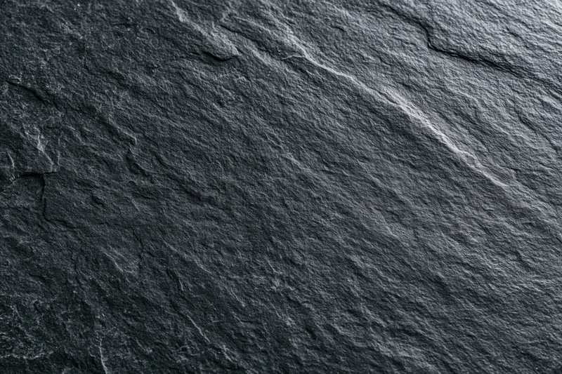 Close-up of dark slate stone surface with natural cracks and texture