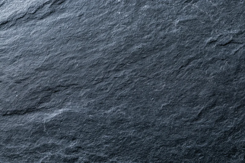 Close-up of dark slate stone surface with natural texture and cracks