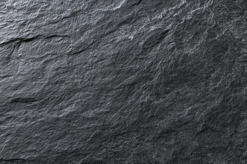 Close-up of dark slate stone surface with natural cracks and texture