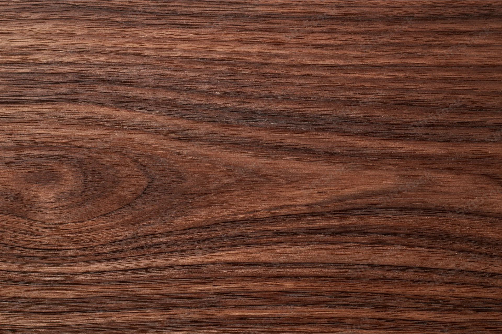 Close-up of dark walnut wood surface with visible grain and texture
