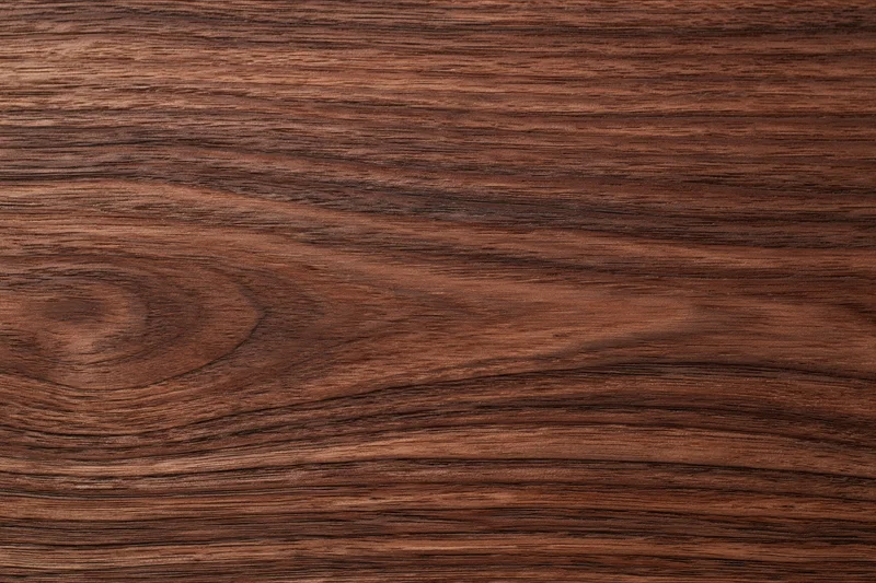 Close-up of dark walnut wood surface with visible grain and texture