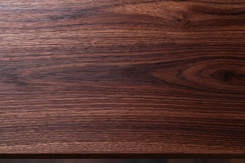 Close-up of dark walnut wood surface showing natural grain and texture