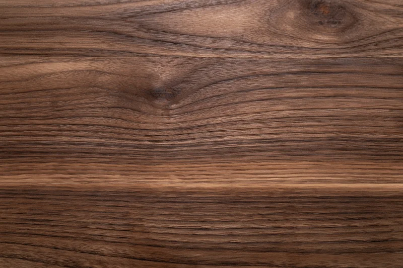 Close-up of dark walnut wood surface showing natural grain and texture