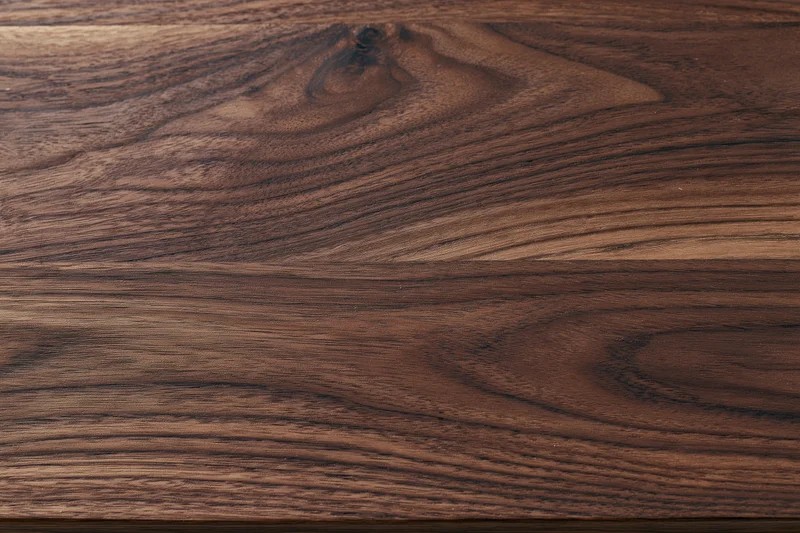 Close-up of dark walnut wood surface showing natural grain and texture