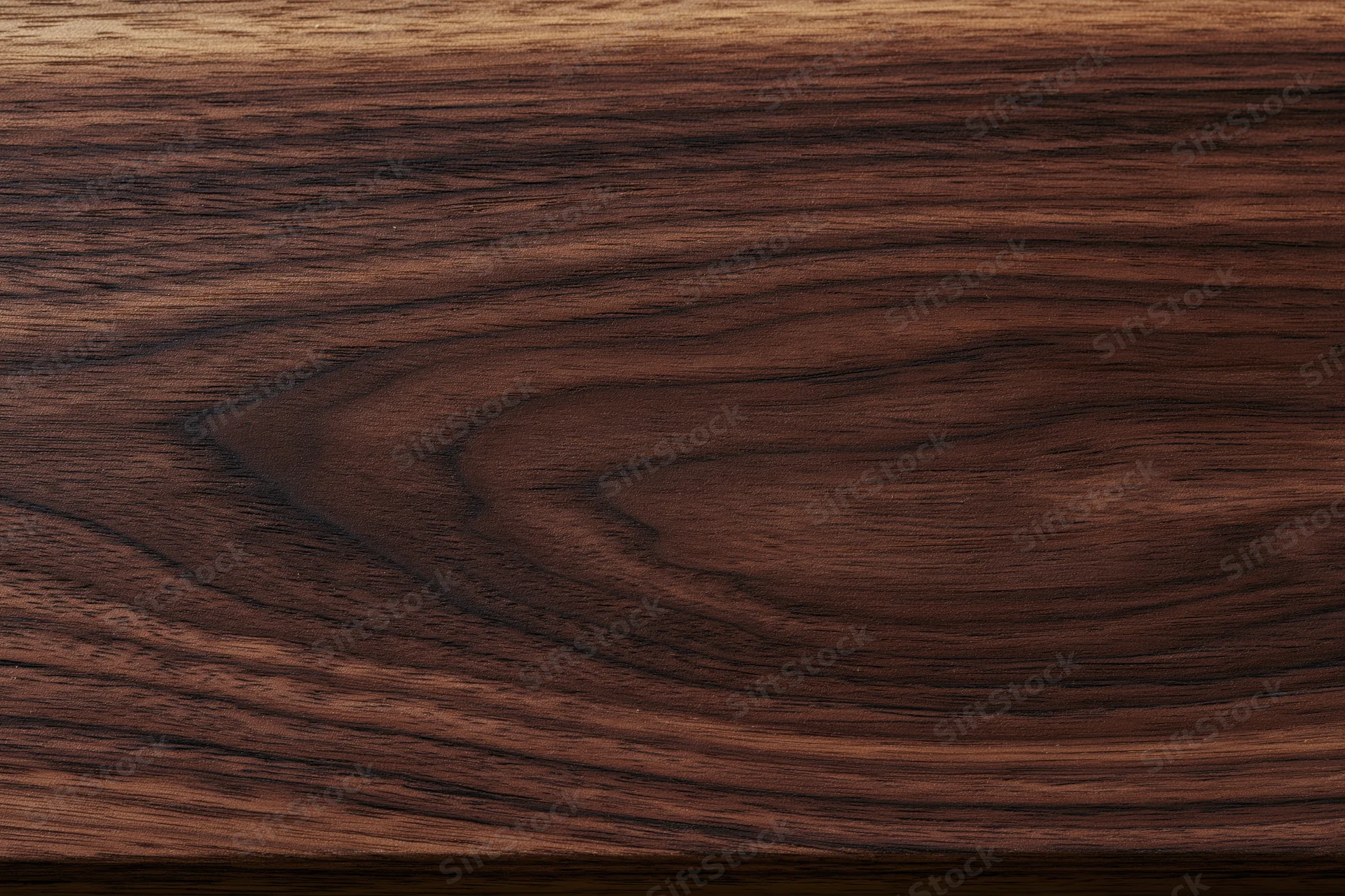 Close-up of dark walnut wood surface showing natural grain pattern