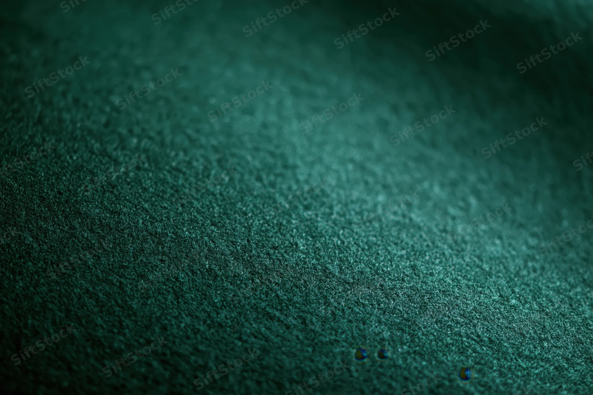Close-up of deep forest green felt fabric with visible texture and subtle shadows