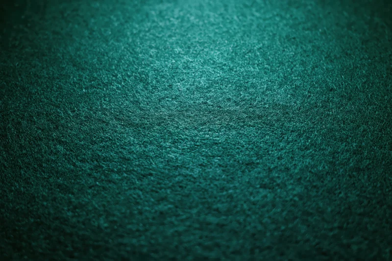 Close-up of deep forest green felt fabric surface with matte texture and subtle grain pattern