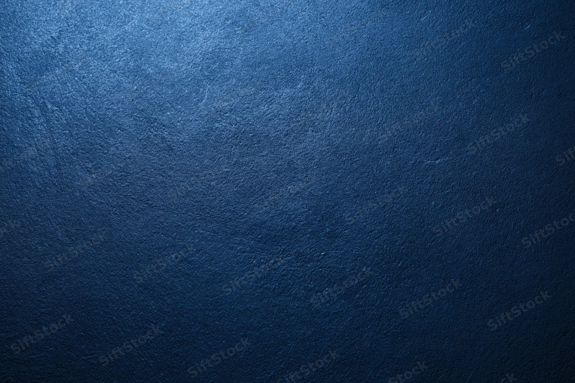 Close-up of a deep navy blue textured surface with subtle lighting gradient