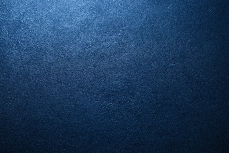 Close-up of a deep navy blue textured surface with subtle lighting gradient