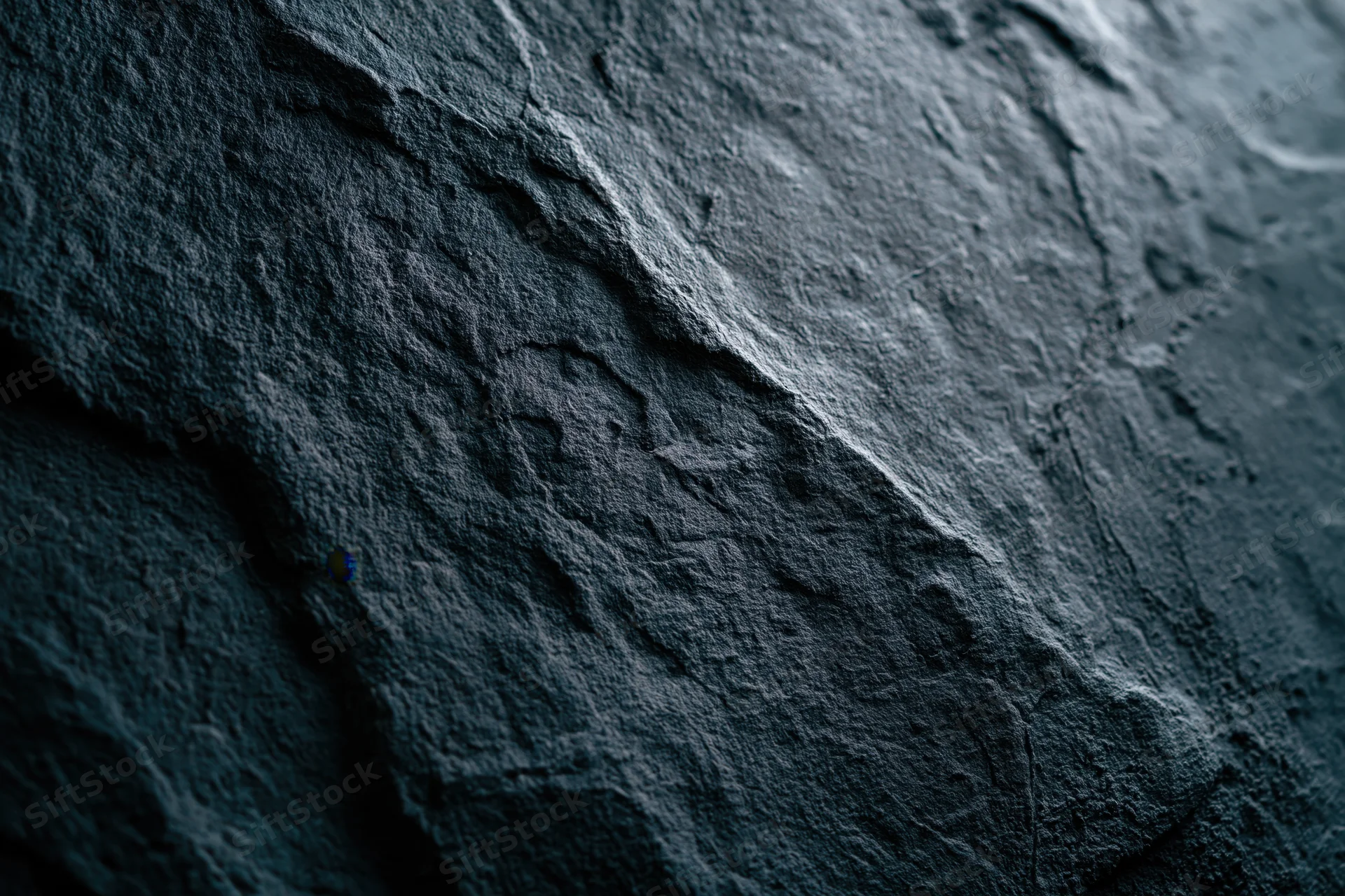 Close-up of rough dark slate surface with natural texture and subtle blue-gray tones