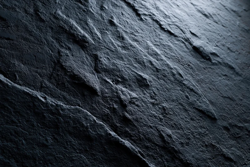 Close-up of dark rough slate surface with natural texture and striations
