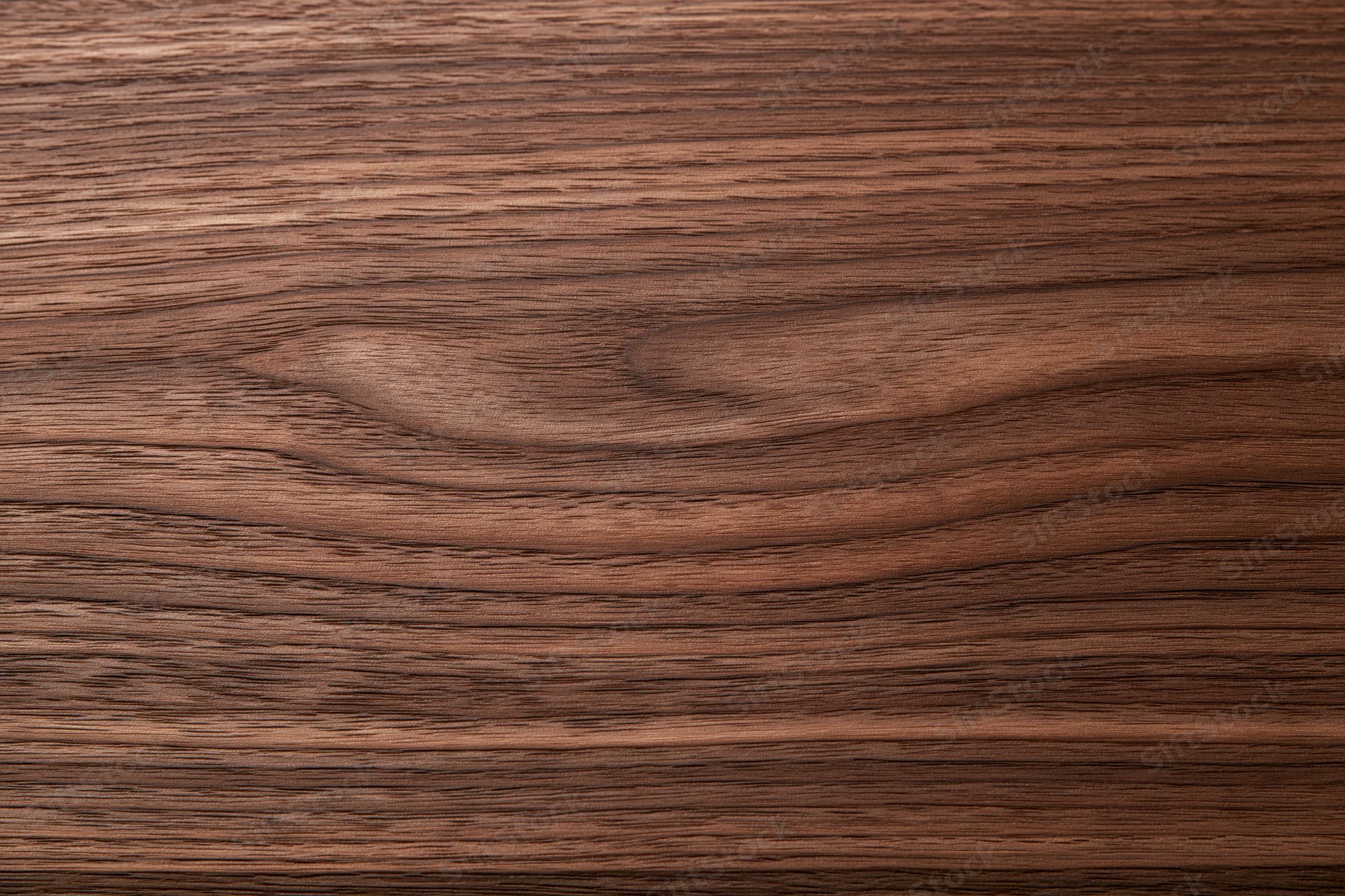 Close-up of smooth dark walnut wood surface with visible grain pattern